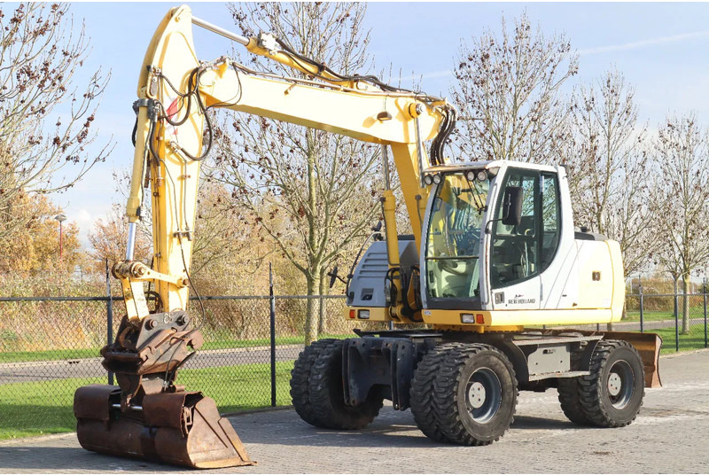 New Holland MH CITY | TILT BUCKET | QUICK COUPLER | DOZER BLADE - Ratastel ekskavaator: pilt 2 New Holland MH CITY | TILT BUCKET | QUICK COUPLER | DOZER BLADE - Ratastel ekskavaator: pilt 2
